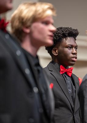 two young men in a singing ensemble