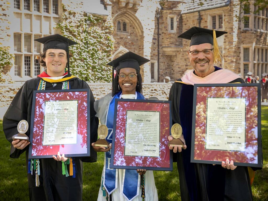 image of three individuals holding plaques