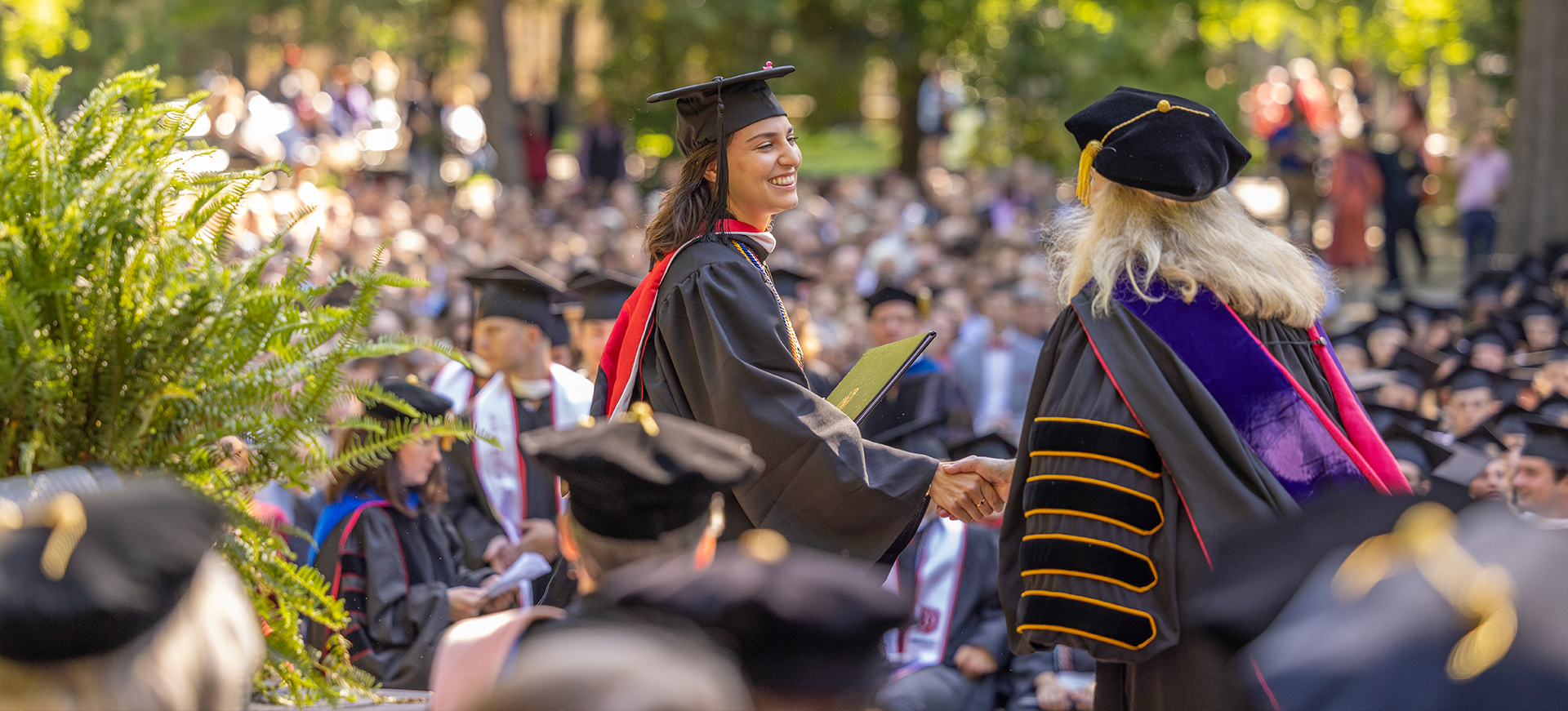 a student shakes the president's hand