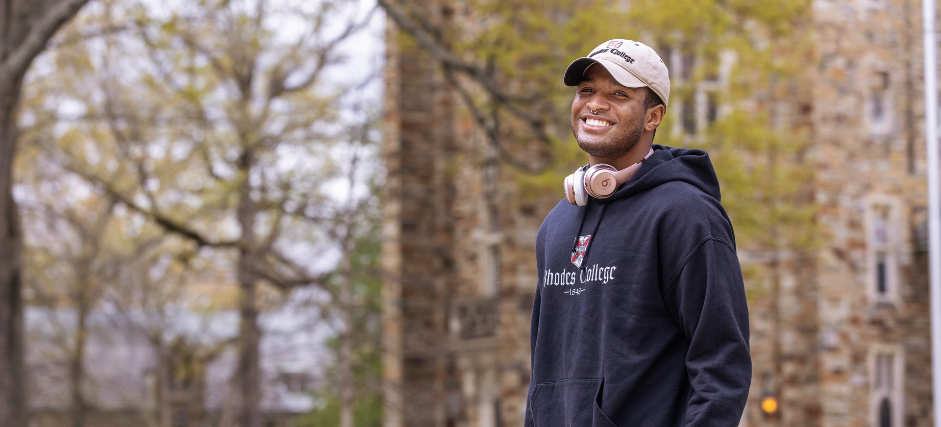 a smiling young African American man in a baseball cap