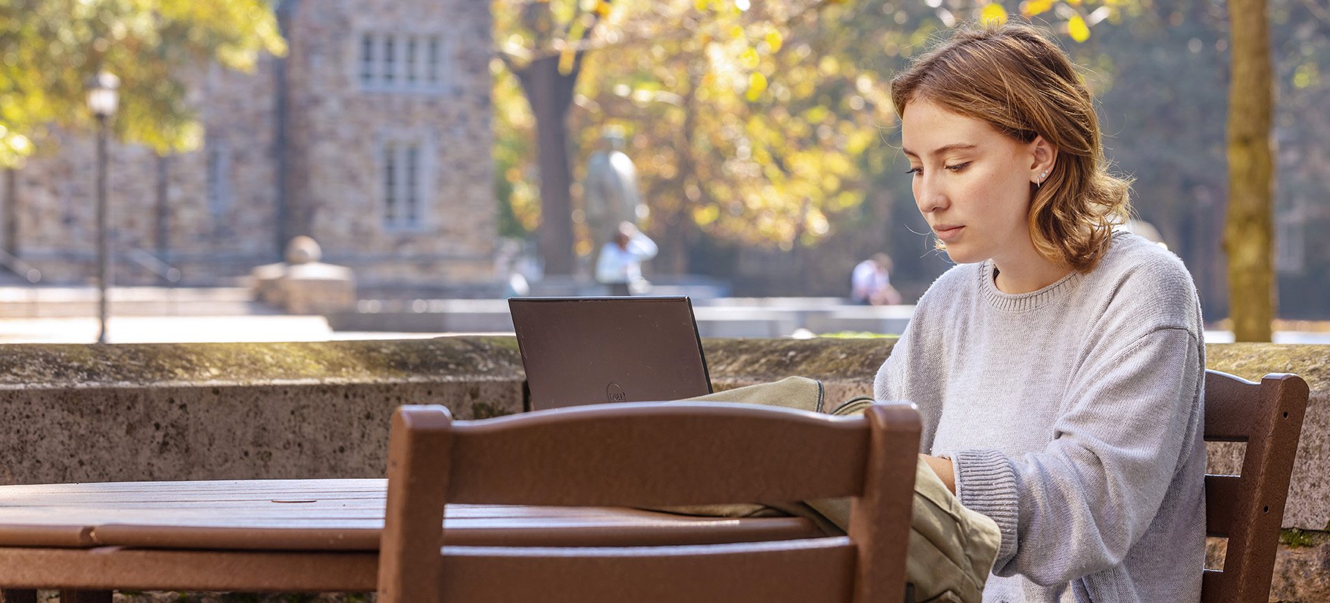 a student studies outside on a fall day