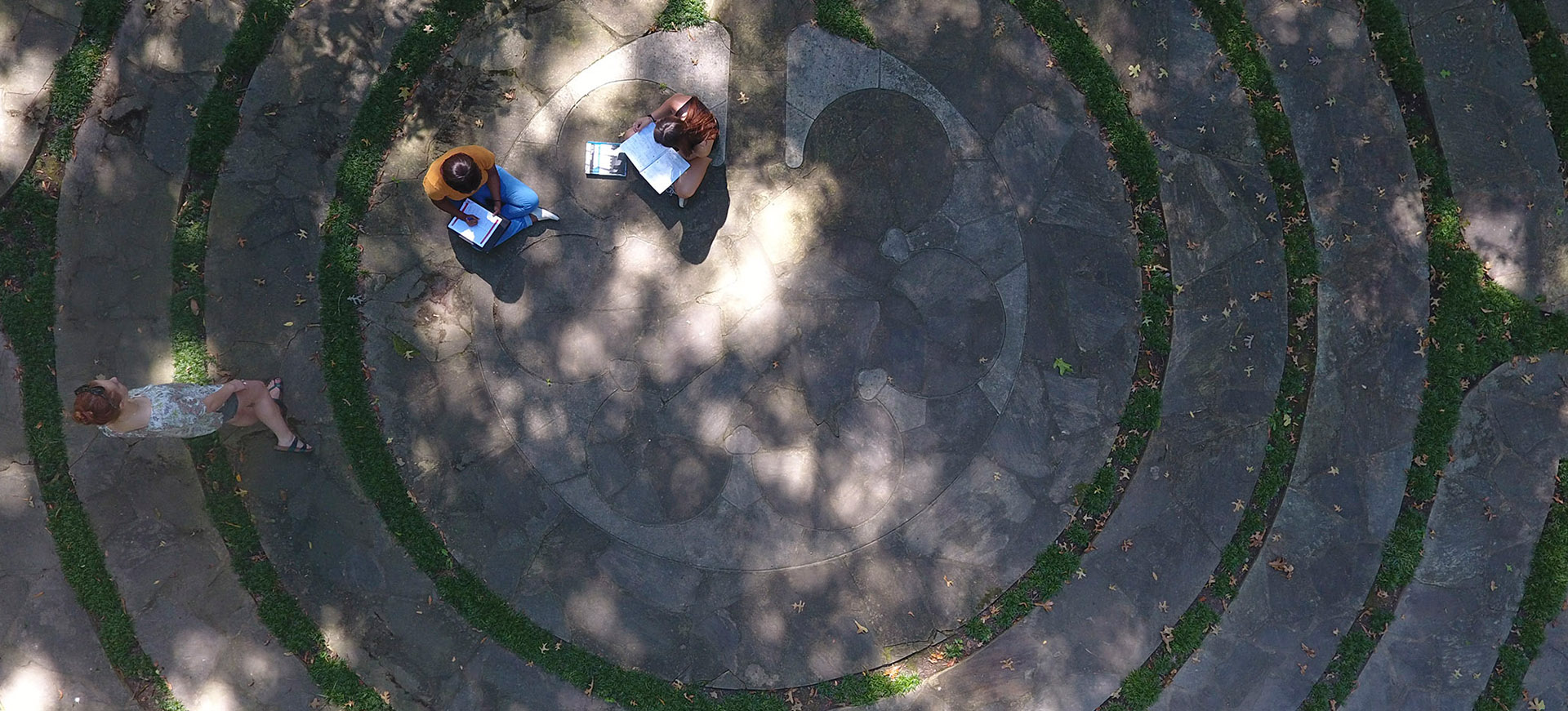 a student walks a labyrinth while others sit and study