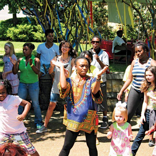 A clapping woman is surrounded by children