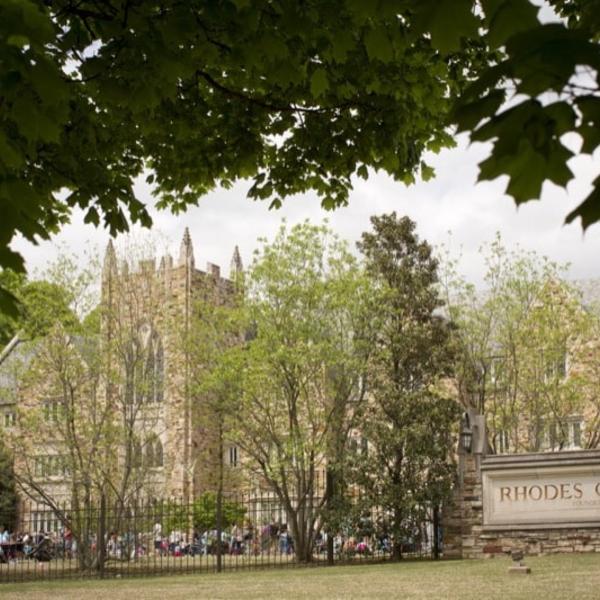 Students gather for a picnic outside a large collegiate gothic building.