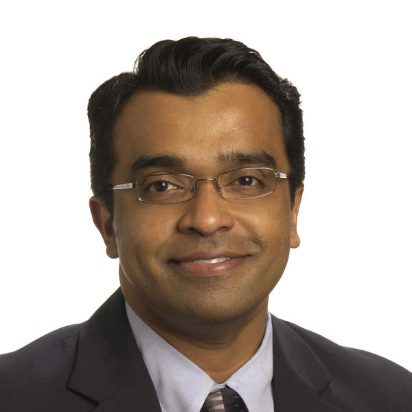 A professor in his suit and tie against a white background.