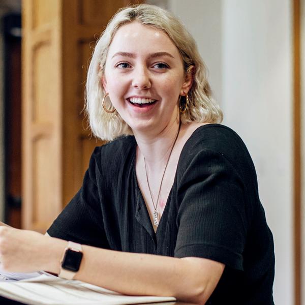 a smiling student working at a table