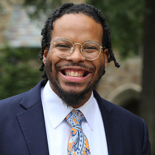 Simeon Glover, a young African American man in glasses and a short beard