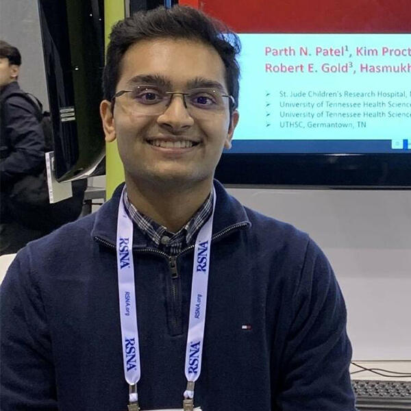 Parth Patel, a young man in front of a poster