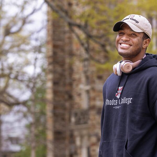 a smiling young African American man in a baseball cap