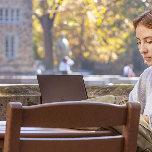 a student studies outside on a fall day