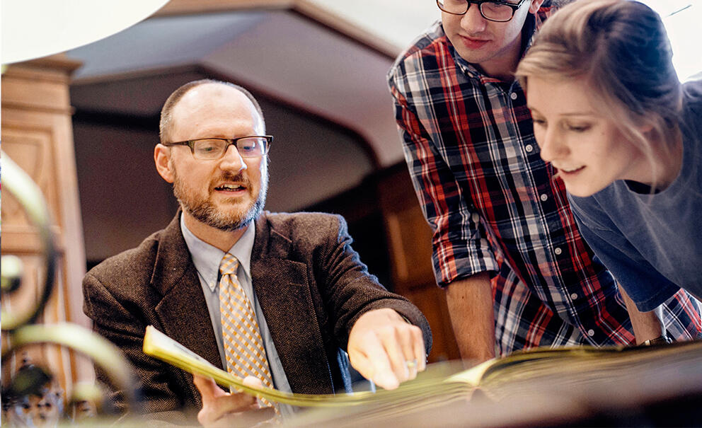 a professor shows a manuscript to students