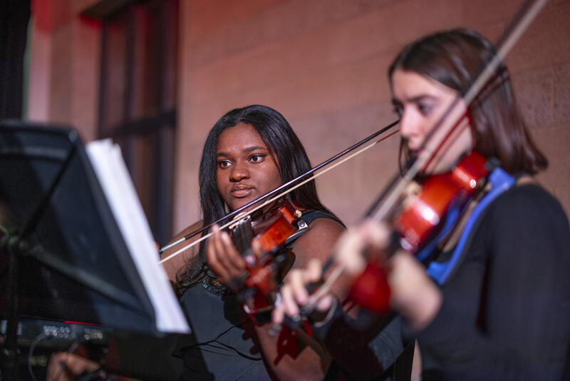 two young women play the violin