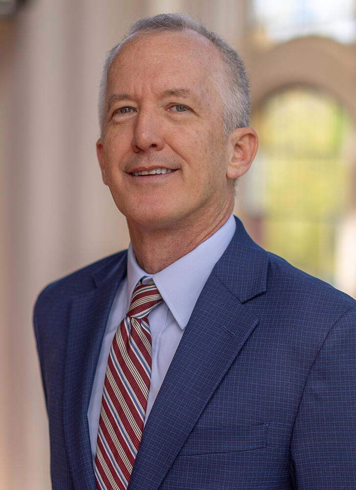 a man in a suit and tie smiles at the camera