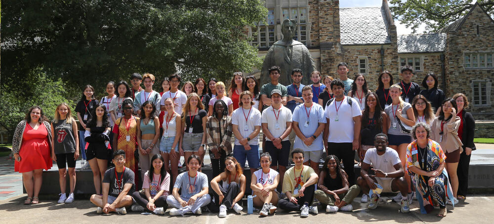 a large group of students in front of a statue