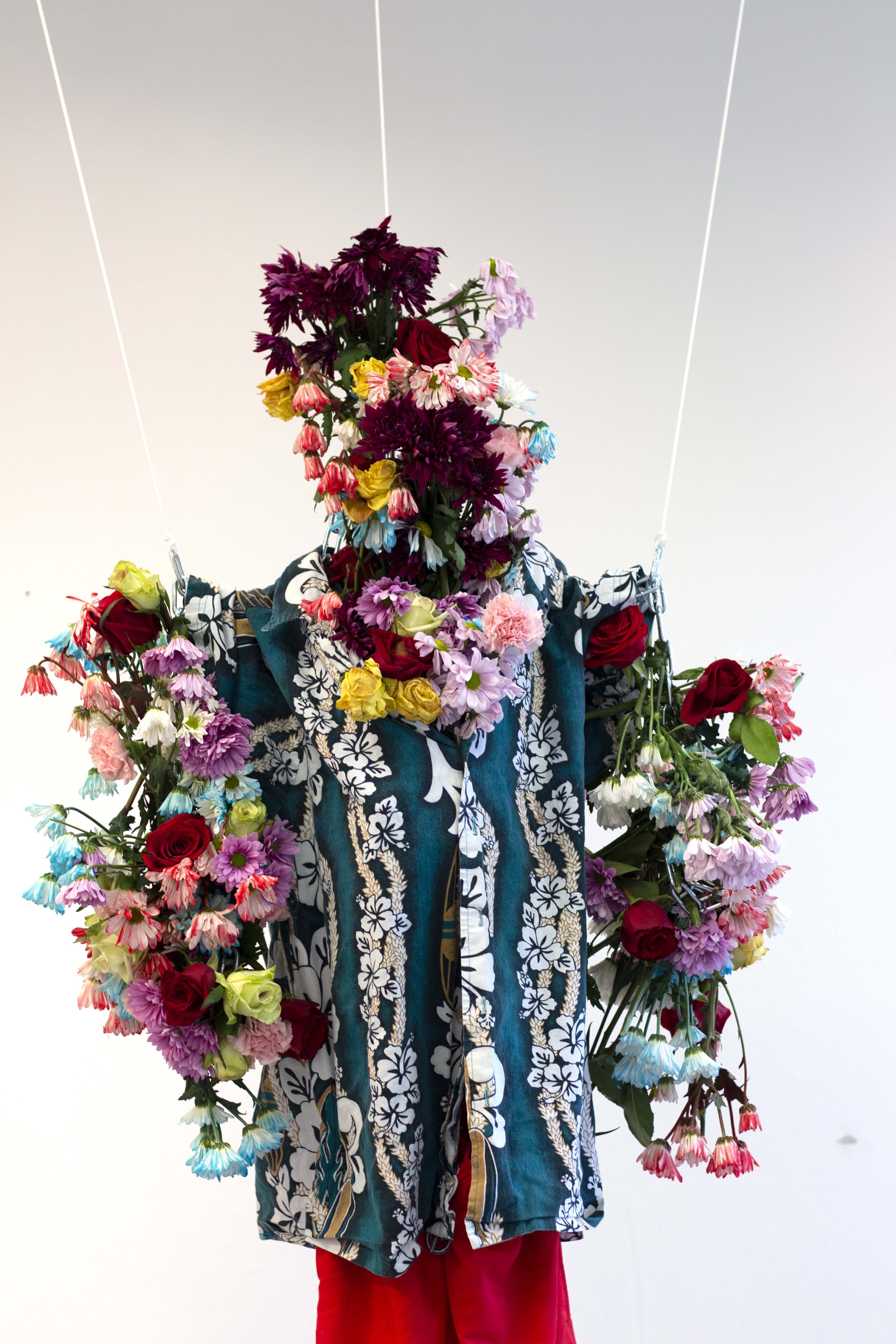 A sculpture made of flowers and clothing.